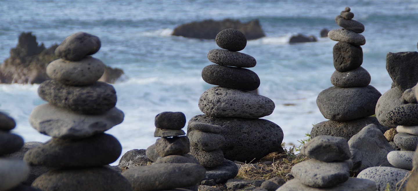 stacks of rocks on the shore of a lake or ocean.