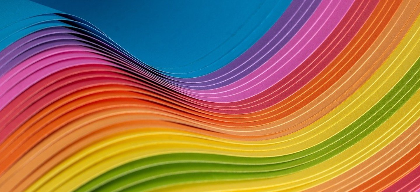 multicolored paper fanned and bent in a wave