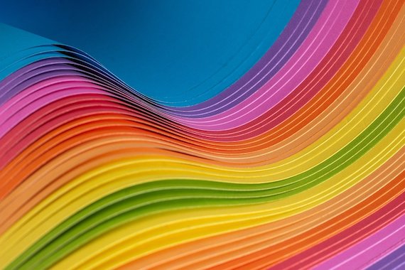 multicolored paper fanned and bent in a wave