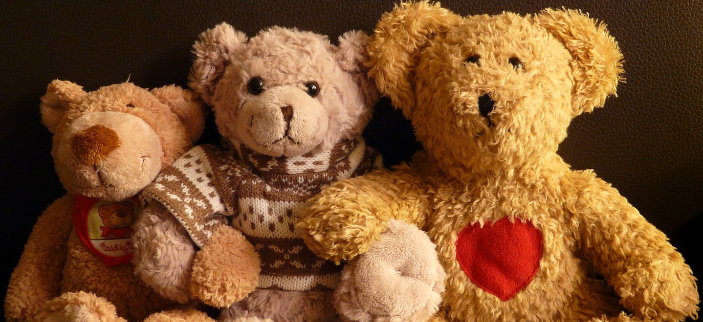 Three teddy bears sitting next to each other.