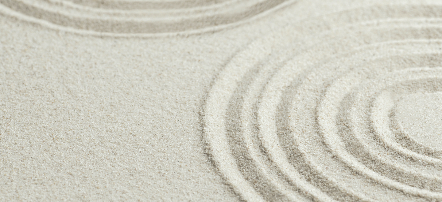 flat sand with concentric circles drawn in it like a zen garden.