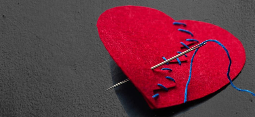 image of a felt heart that has been stitched up with a needl and thread