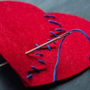 image of a felt heart that has been stitched up with a needl and thread